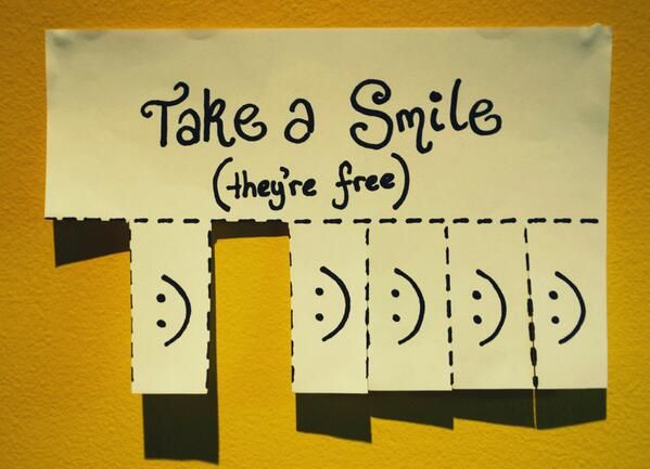 there is a sign that says take a smile and there are three faces on it