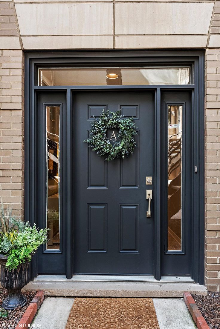 a black front door with a wreath on it