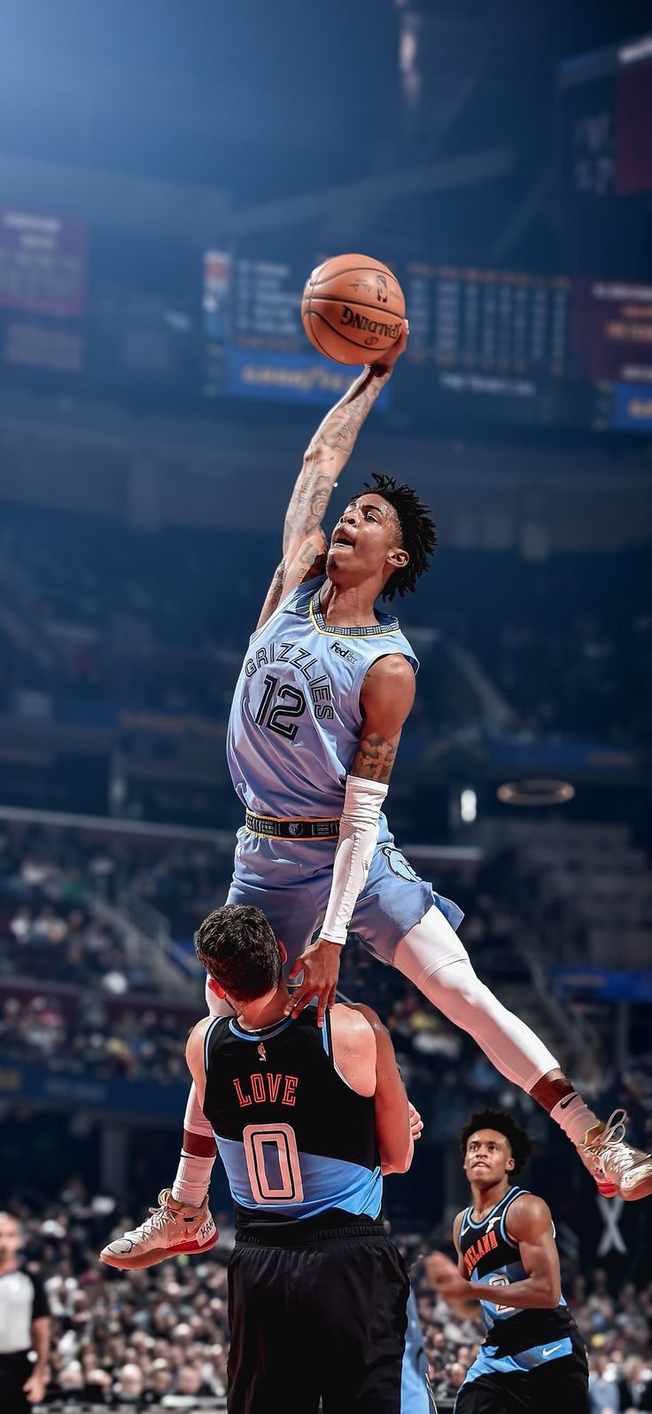 a basketball player jumping up into the air to dunk a ball in front of two other players