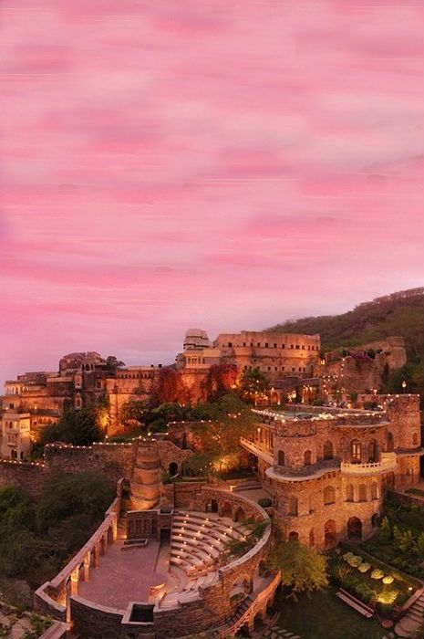 an aerial view of the city at dusk, with pink clouds in the sky above