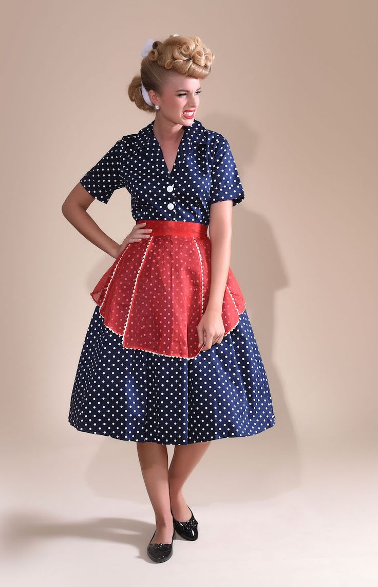 a woman in a polka dot dress poses for the camera with her hands on her hips