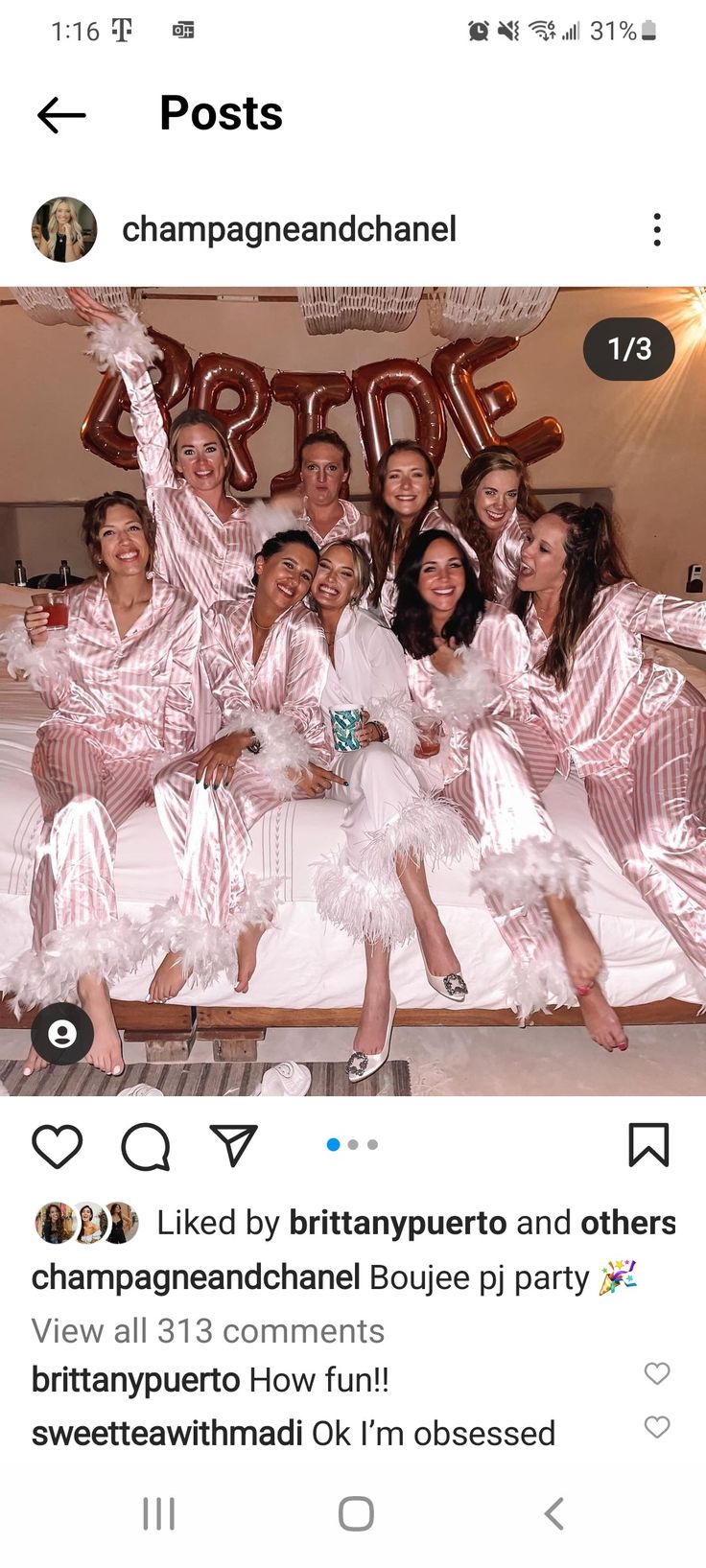 a group of women in pink pajamas posing for a photo on a bed with balloons