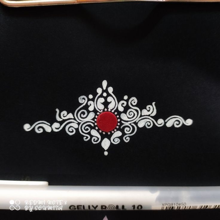 a black bag with white and red designs on the front is next to a pair of scissors