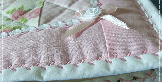 a close up of a pink quilt on a bed