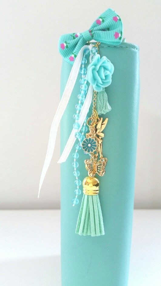 a blue vase with some tassels on the side and a bow tie around it