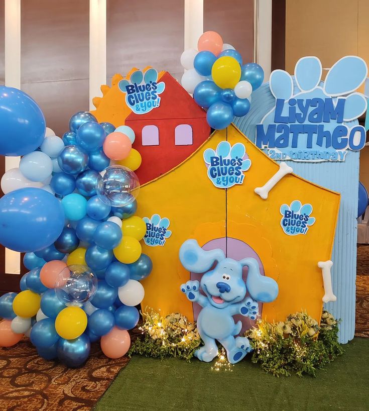 there is a blue elephant themed birthday party with balloons and streamers on the table