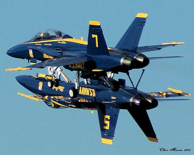 two blue fighter jets flying in the sky