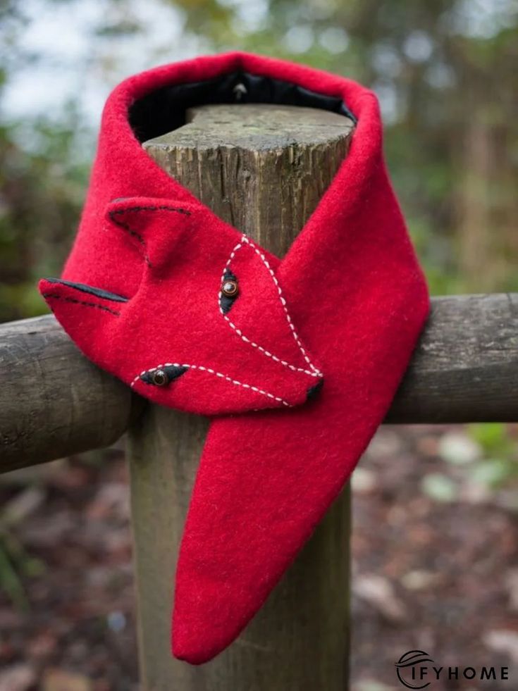 a red scarf is hanging on a wooden post