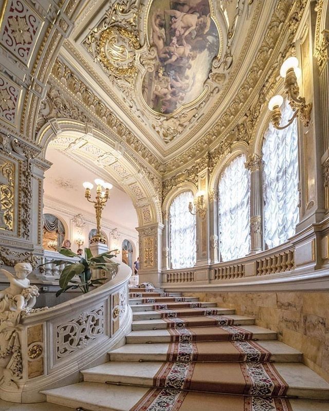 an ornately decorated staircase leads up to the second floor