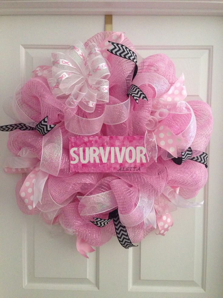 a pink and black wreath with the word survivor on it hanging on a white door