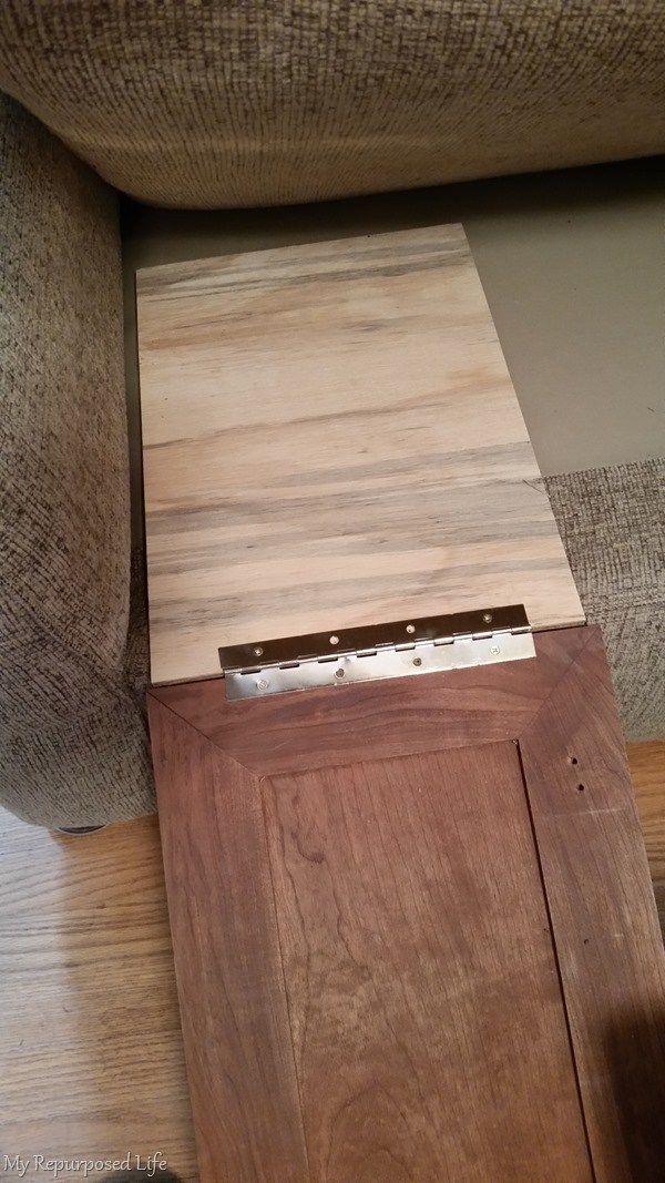 a piece of wood sitting on top of a wooden floor next to a couch and chair