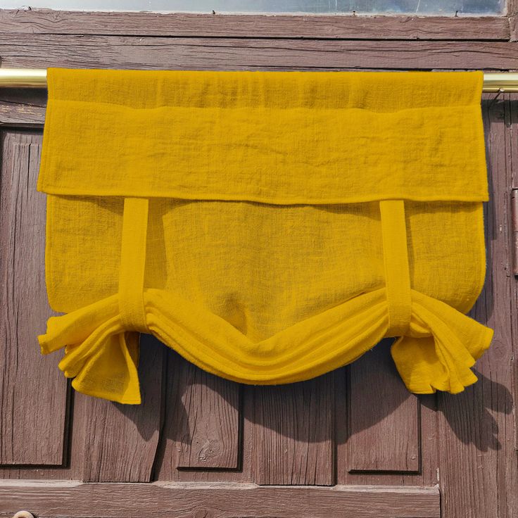 a yellow curtain hanging on the side of a wooden door