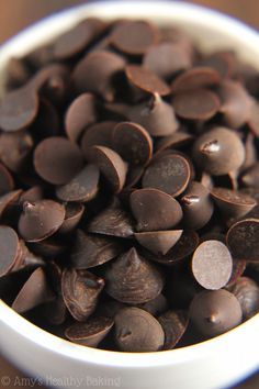 a white bowl filled with chocolate hearts on top of a wooden table