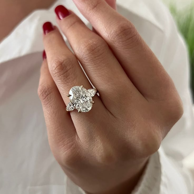 a woman's hand holding a diamond ring