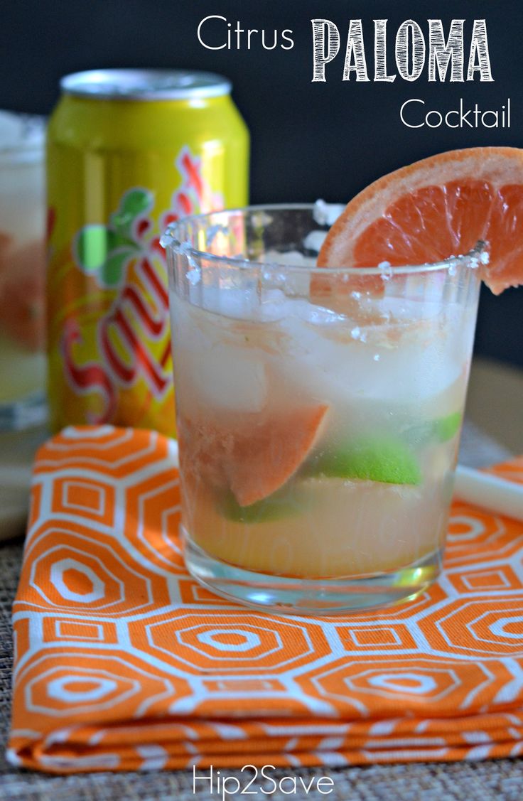 a close up of a drink in a glass with an orange slice on the rim