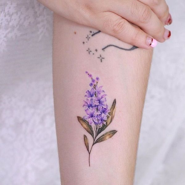 a woman's arm with purple flowers on it