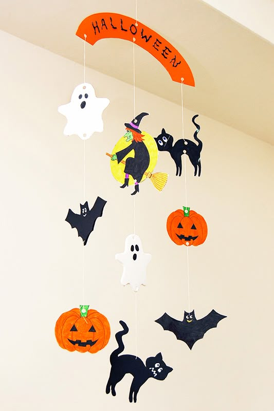 halloween decorations hanging from the ceiling in a room