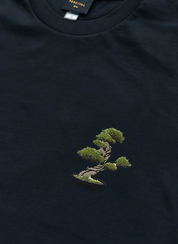 a black t - shirt with a bonsai tree embroidered on the front and back