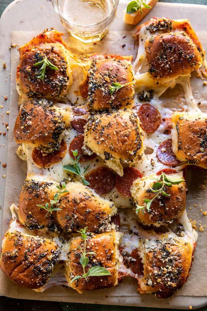 pepperoni and cheese sliders on a sheet of parchment paper with sprinkles