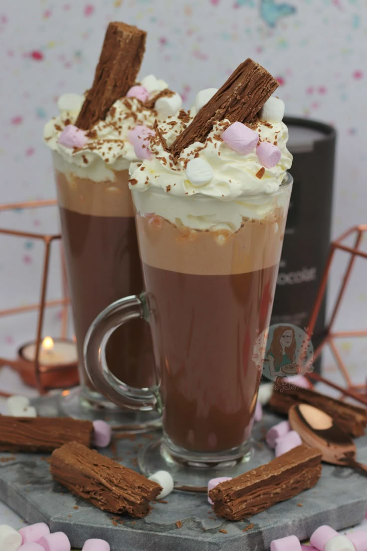 two cups filled with hot chocolate and marshmallows