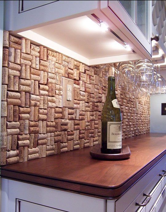 a bottle of wine sitting on top of a wooden counter next to a cork wall