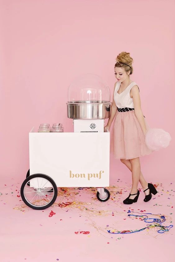 a woman standing next to a cart with confetti on it and confetti wheels