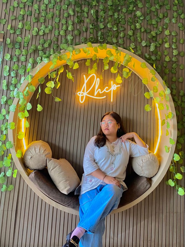 a woman is sitting on a round bench with pillows in front of her and the word hope written above it