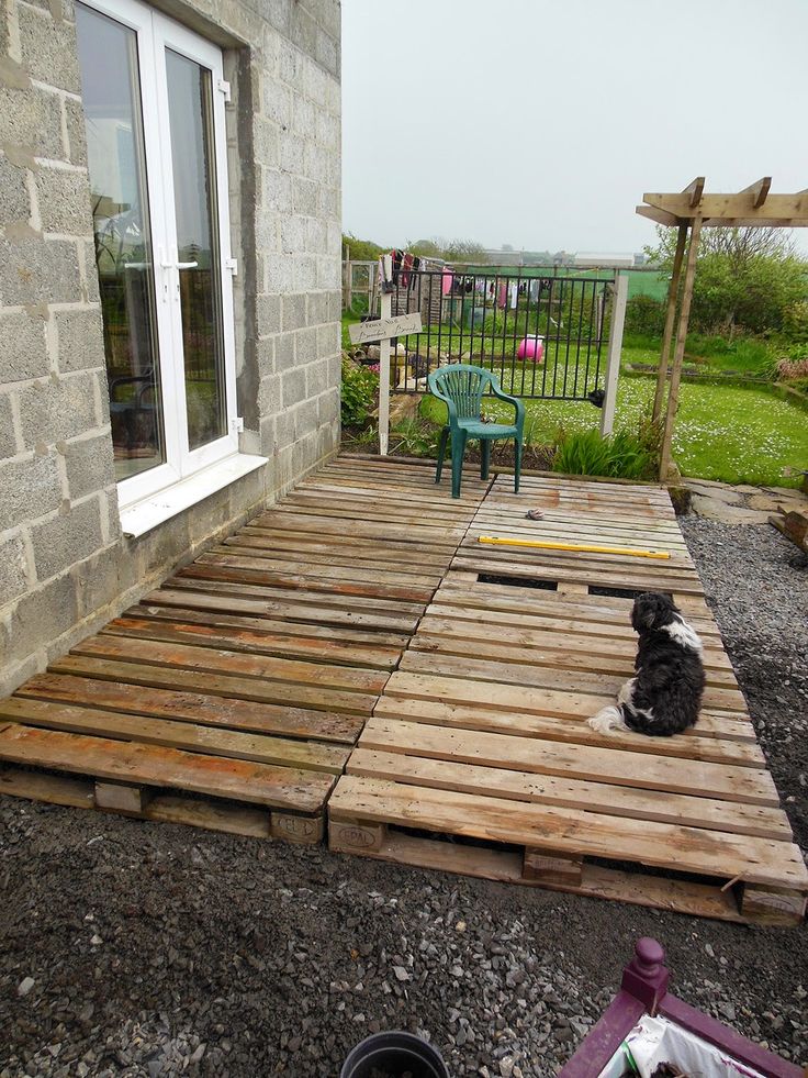 a dog sitting on top of a wooden deck