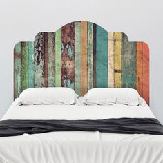 a bed with colorful wood headboard and pillows