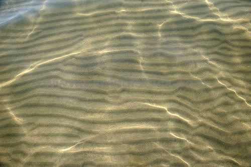 an image of sand and water at the beach or ocean shore with small ripples in it