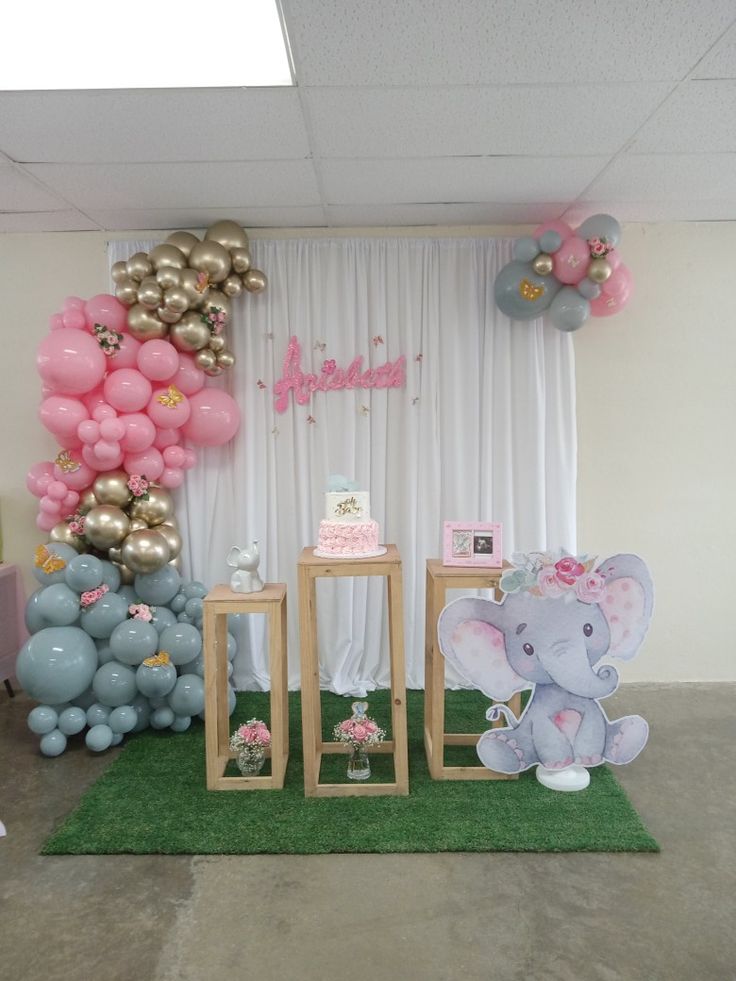 an elephant themed birthday party with balloons and decorations on the wall, table and chairs