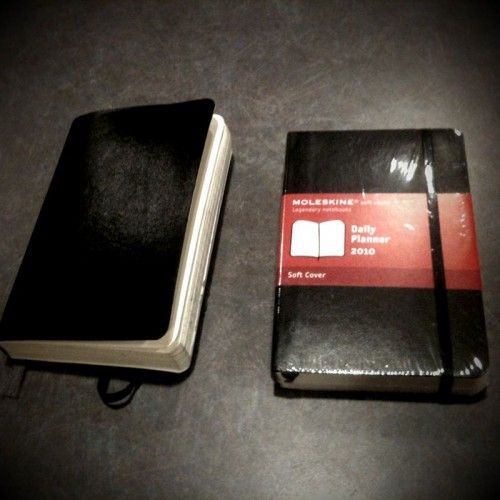 two black and red notebooks sitting next to each other on top of a table