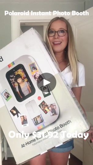 a woman holding up an open polaroid instant photo booth