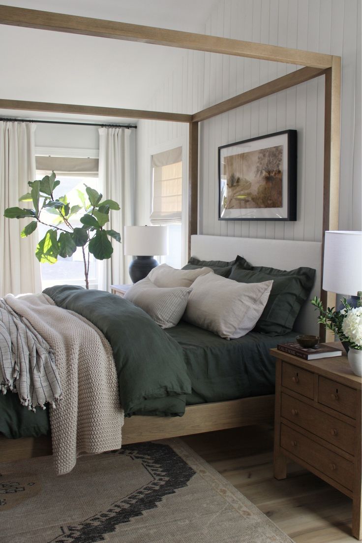 a bed with green sheets and pillows in a bedroom