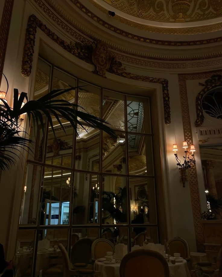 the inside of a restaurant with chandeliers, tables and chairs in front of it