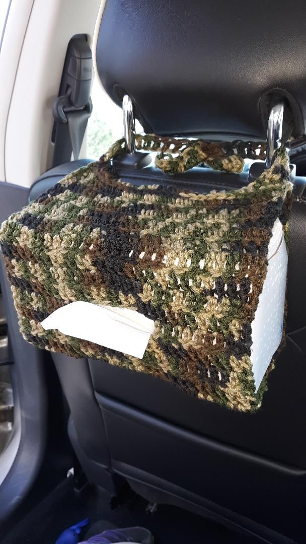 a crocheted purse hanging from the back seat of a car with paper stuck to it