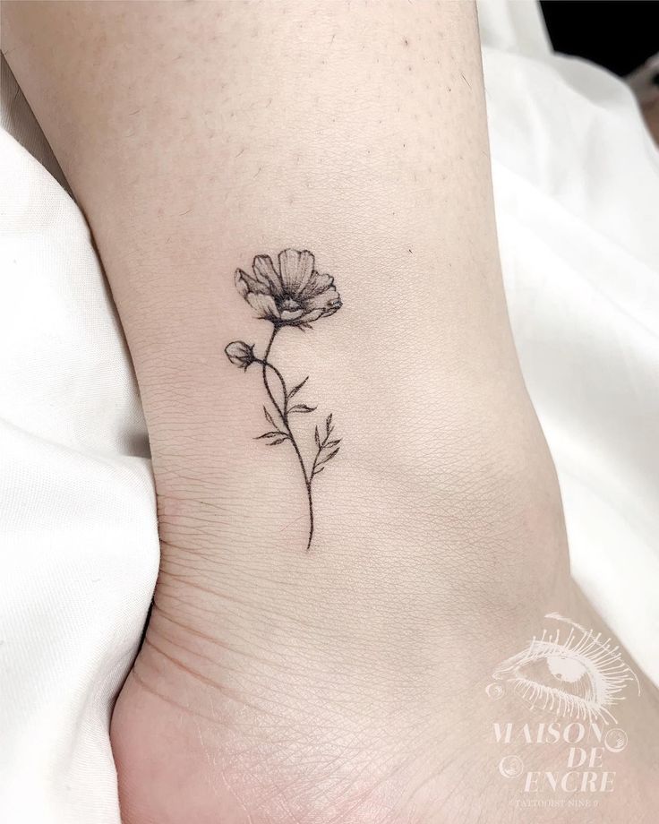 a small flower tattoo on the ankle