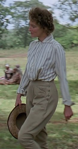 a woman walking across a lush green field