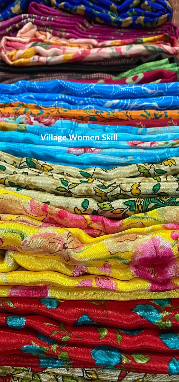 many different colored fabrics are stacked on top of each other, with the words village women skill