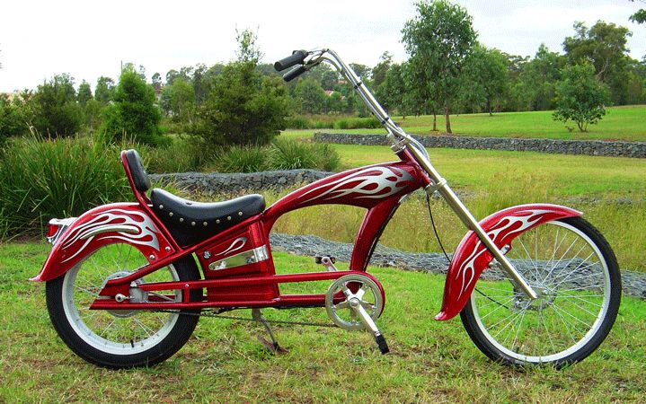 a red motorcycle parked on top of a lush green field