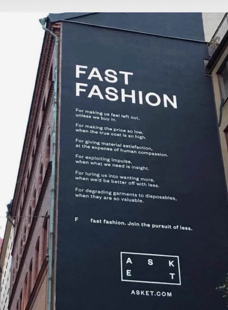 a large black sign on the side of a building that says fast fashion and it is written in white