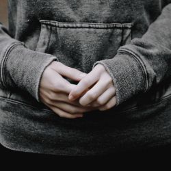 a person with their hands in the pocket of his jacket that is folded over them