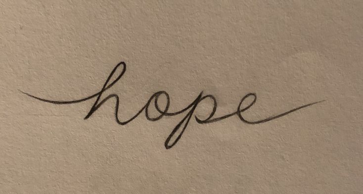 the word hope written in cursive writing on a white wall with black ink