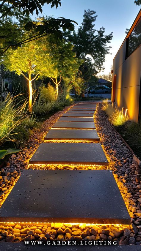 an outdoor walkway lit up with leds and graveled path leading to the house