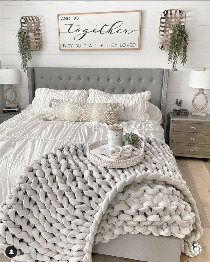 a bed with white comforter and pillows on it in front of a sign that says together