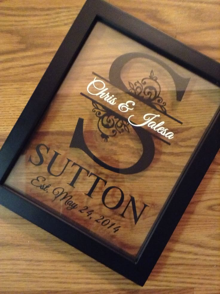 a wooden table topped with a framed sign that says, save the date and sutton