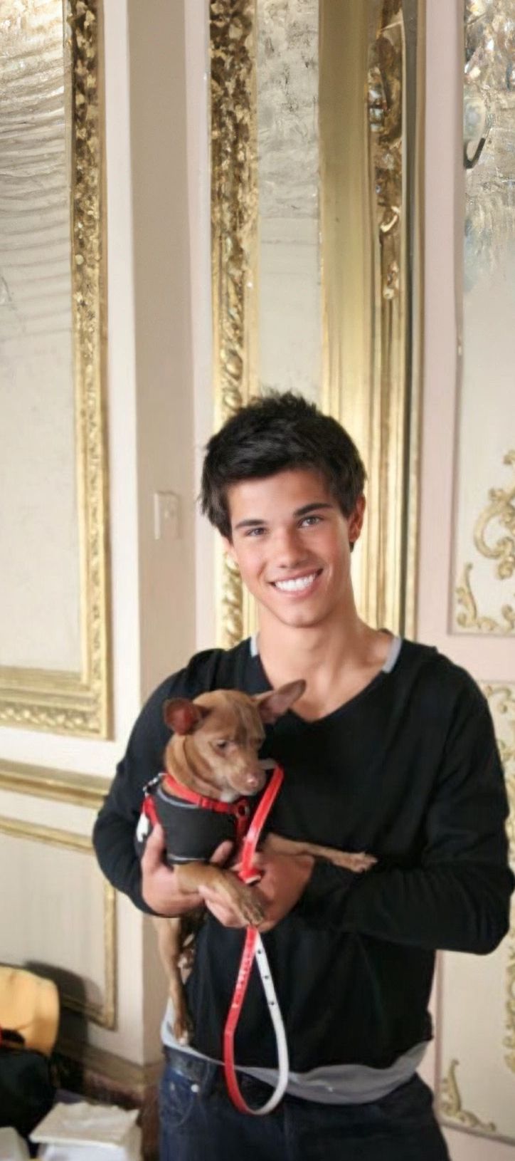 a young man holding a small dog in his arms