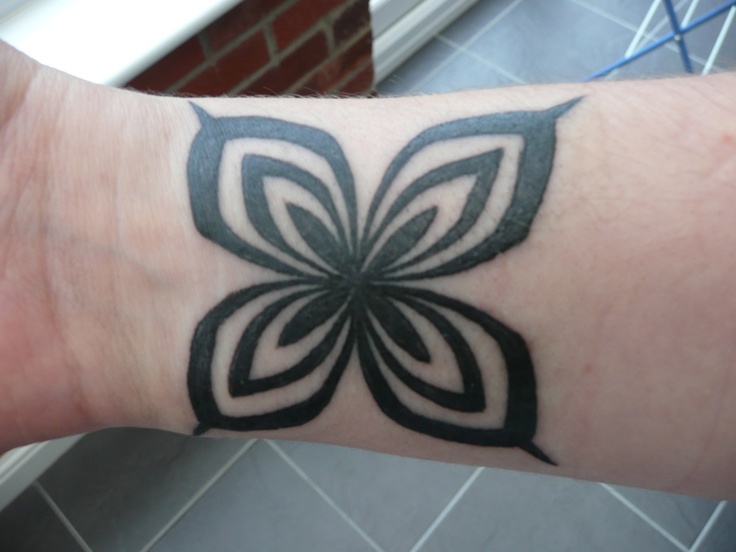 a person with a tattoo on their arm that has a flower design on the wrist