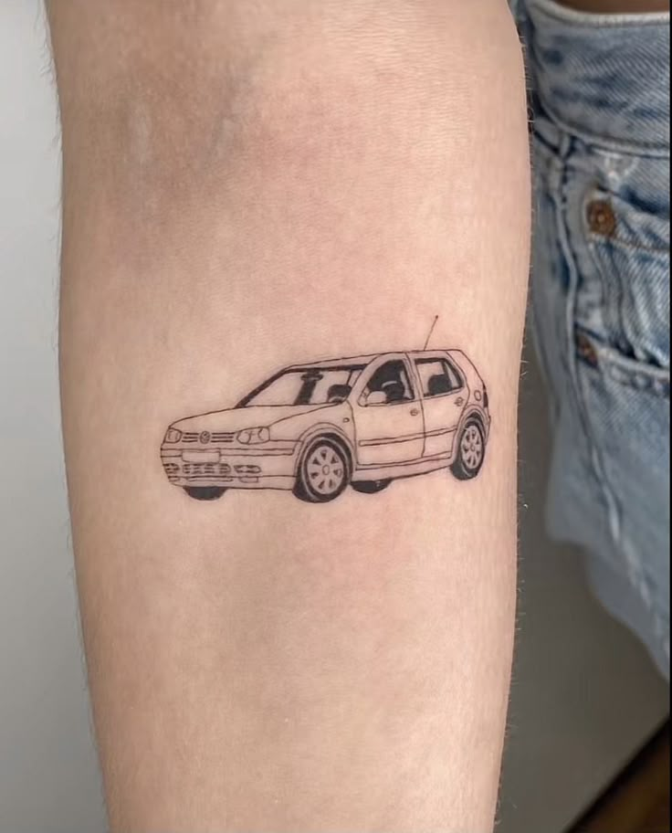 a small car tattoo on the arm