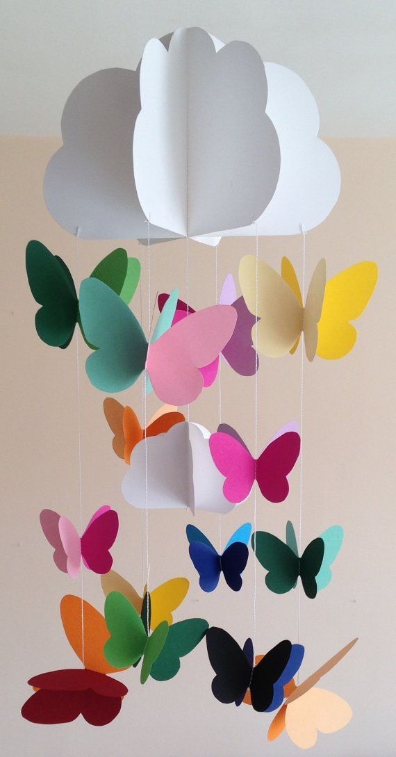 a mobile made out of paper with butterflies hanging from it's sides and clouds in the background